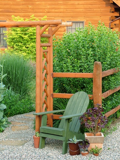 Chair outside courtyard arbor early July 05